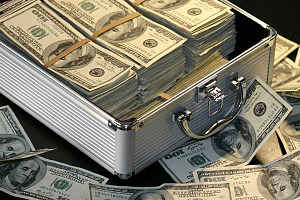 Love and Money Part 2: Photo of briefcase filled with 100 bills, with some bills scattered around